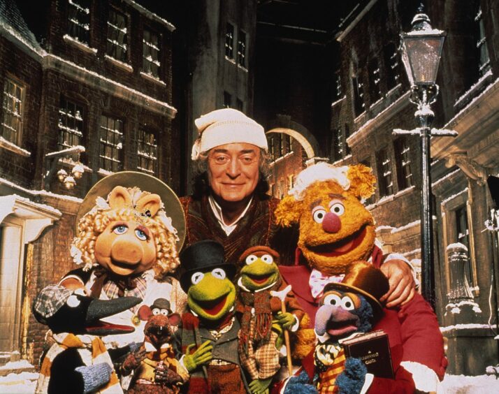 photo shows Michael Caine and the cast of A Muppet Christmas Carol.