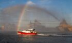 Vessels discharge water cannons and create a rainbow as the new pilot boat at Montrose harbour arrives. Image: Paul Reid.