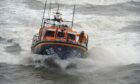RNLI Arbroath crew members were called to help rescue the dog after falling from the cliffs. Image: Kim Cessford/DC Thomson