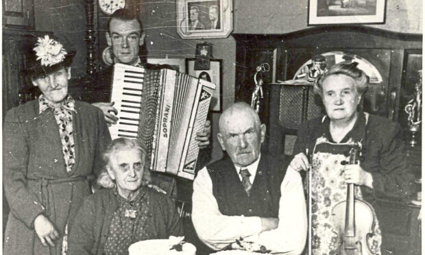 Mary Brooksbank with nephew Fred Soutar (with accordion), parents Rosie and Sandy Soutar (seated) and their friend Mrs Hughes (standing), at her parents' diamond wedding anniversary in 1948.