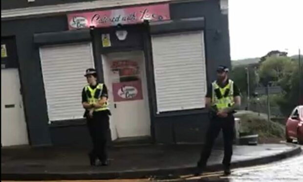 Police stationed outside the shop during a protest against sex offender owner Sean McGowan. Image: Facebook.