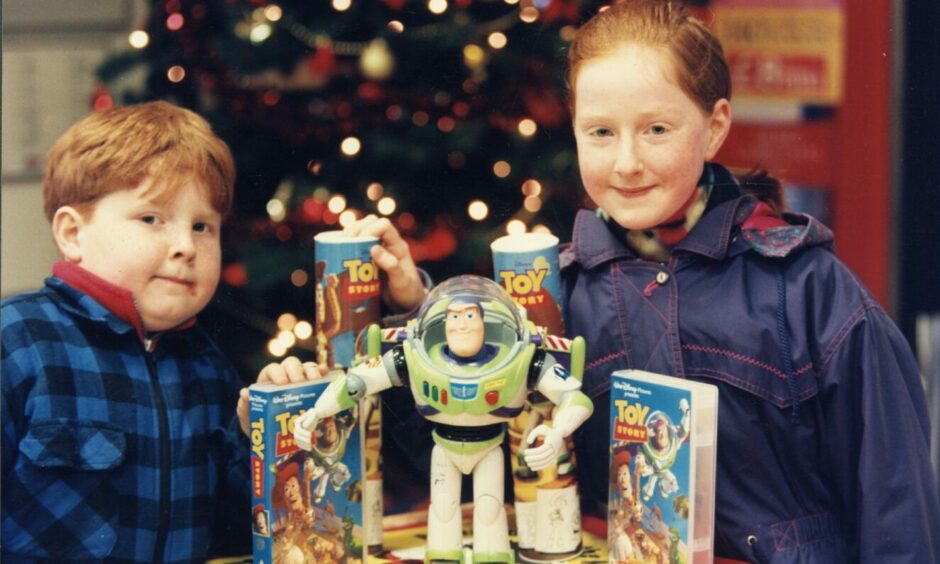 The Buzz Lightyear toy which was being auctioned at Tesco in Lochee with youngsters Thomas Brady and Ruth Hastie. Image: DC Thomson.