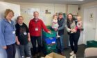 Parkrun organisers hand over the donation to foodbank volunteers. Image: Forfar Loch parkrun.