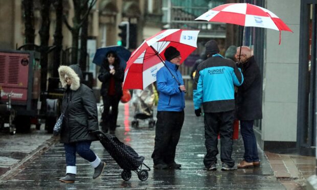 Picture of people under umbrellas as Met Office issue yellow weather warning for Tayside, Fife, Angus and Perth.