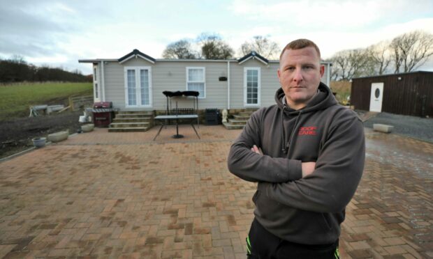 Ross Townsley in front of his caravan, which he must remove from his land. Image: Gareth Jennings/DC Thomson