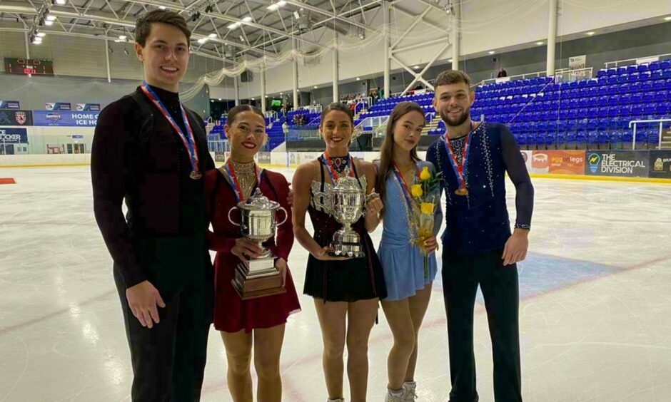 photo shows Luke Digby, Anastasia Vaipan-Law, Natasha McKay, Lucy Hay and Kyle McLeod lined up on the ice with their trophies.