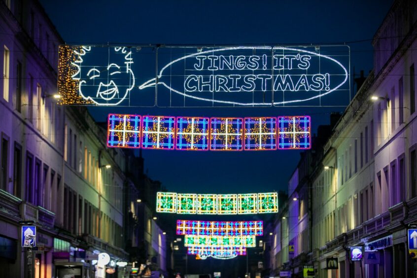 Christmas lights over Reform Street, Dundee, including an Oor Wullie face saying 'Jings! It's Christmas'.