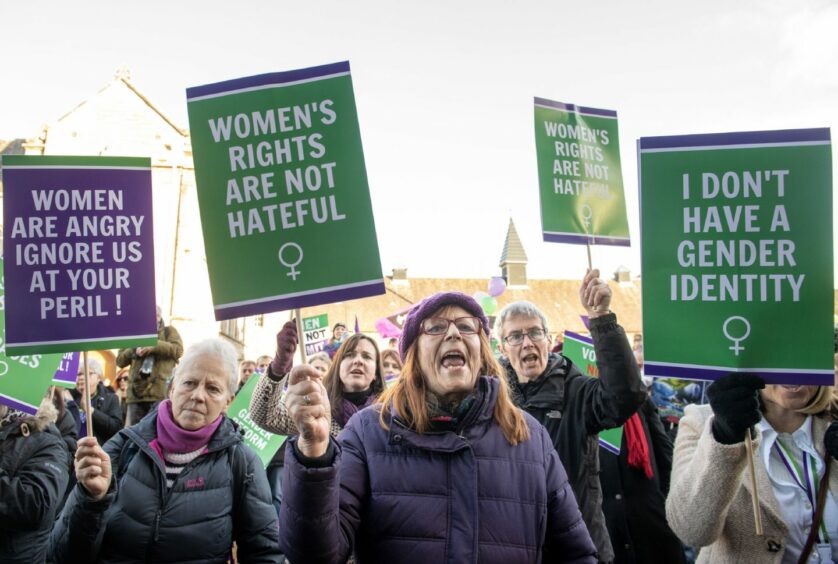 Opponents of the Gender Recognition Reform (Scotland) Bill, holding placards which read 'Women's rights are not hateful' and 'Women are angry, ignore us at your peril'.