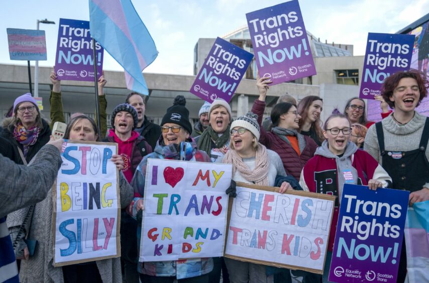 Supporters of the Gender Recognition Reform Bill (Scotland)holding 'Trans rights now' placards outside the Scottish Parliament.