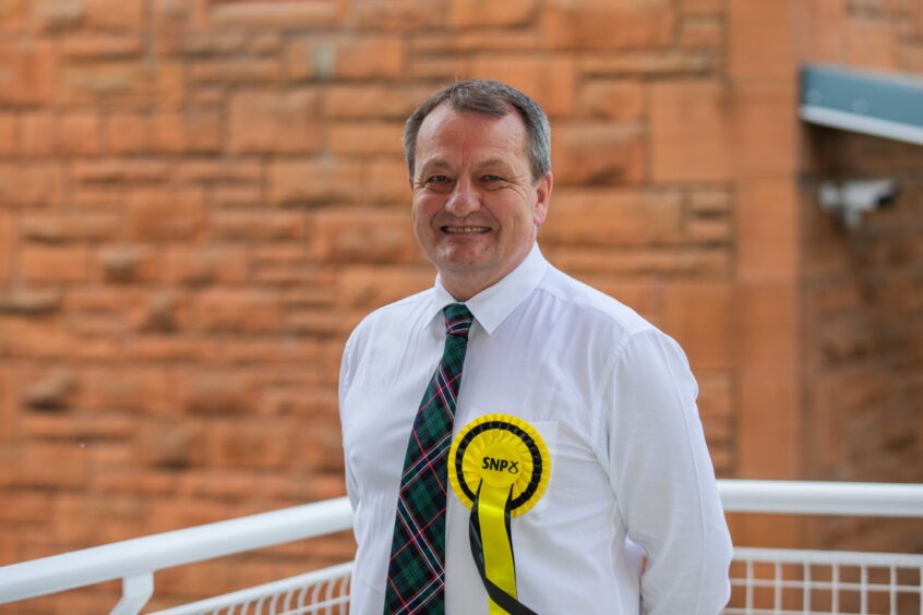 Ian Massie in shirt and tie wearing SNP rosette
