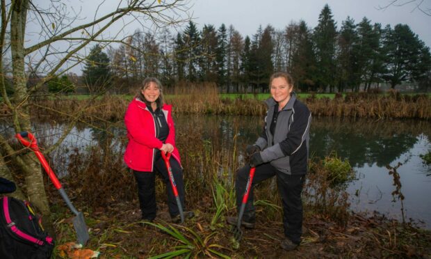 Volunteers want to make ponds more habitable for amphibian and insect populations. Melanie Chad (left, from Bridge of Earn) and right is Nikki Murphy (from Stanley) at North Inch Pond, Perth. Image: Steve MacDougall / DC Thomson