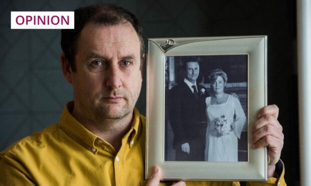 photo shows Les Johnson holding a photo of him and his late wife Ruth on their wedding day.