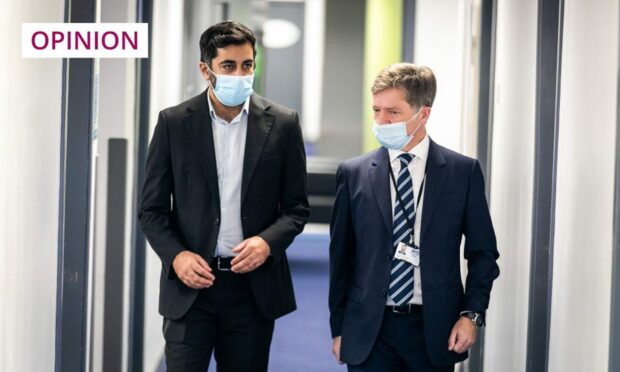photo shows health secretary Humza Yousaf and NHS Tayside chief executive Grant Archibald walking through a medical building.