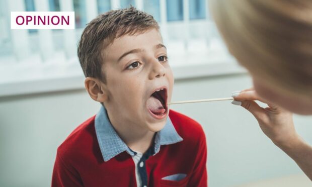 small boy having his throat swabbed.