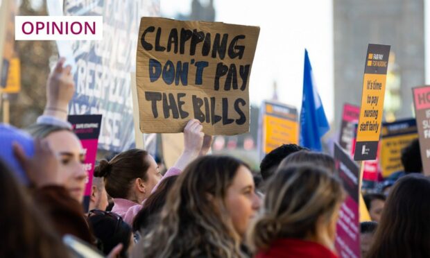 striker holding a sign which reads 'Clapping don't pay the bills'.