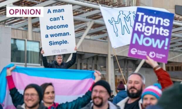 protesters, one waving a banner which reads 'Trans right now', the other witha placard which reads 'A man can't become a woman. Simple.'