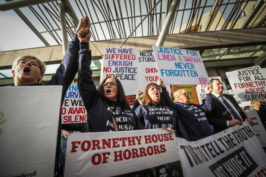 Protesters holding placards with slogans such as 'Fornethy house of horrors' and 'We have suffered enough: no justice, no peace'.
