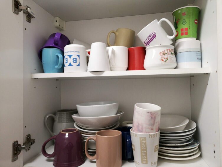 cupboard filled with mugs, none of which match.