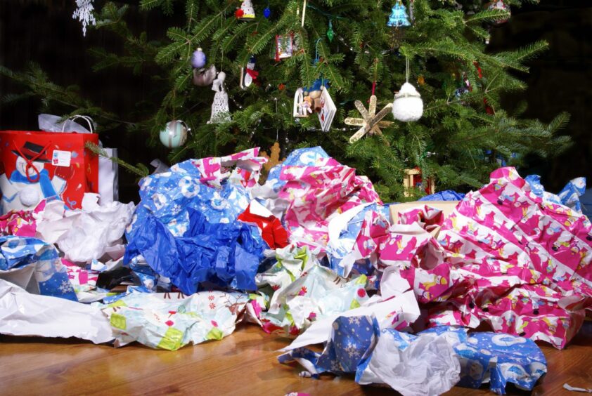 a pile of wrapping paper under a Christmas tree.