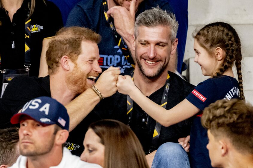 Prince Harry fist bumping a young girl in the crowd at the Invictus Games.