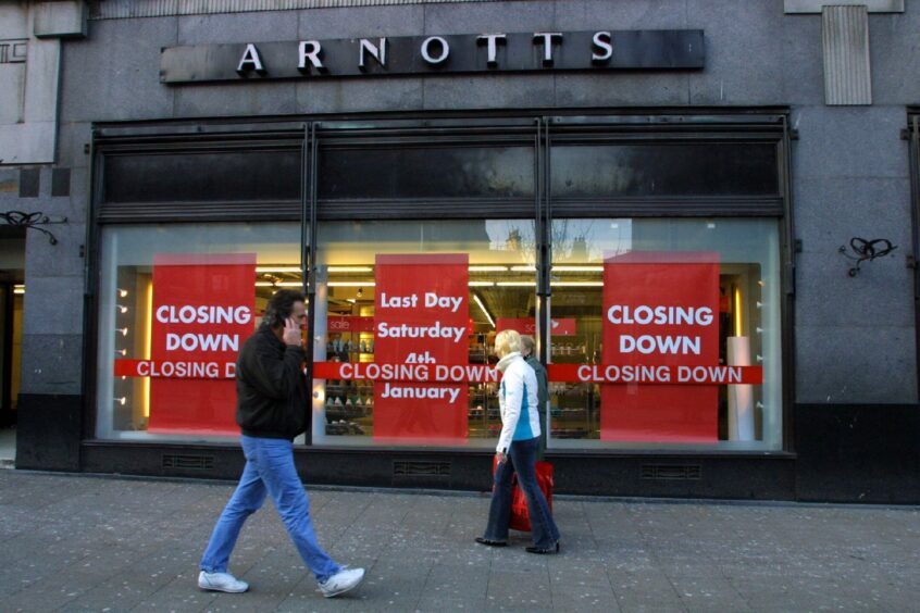 pedestrians walk past the Dundee Arnotts shop front