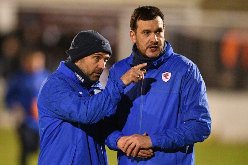 Colin Cameron stands beside Raith Rovers Manager Ian Murray and points something out.