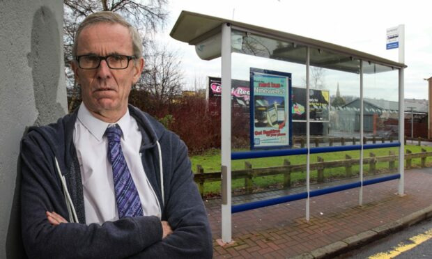 Councillor Fraser Macpherson outside a bus stop.