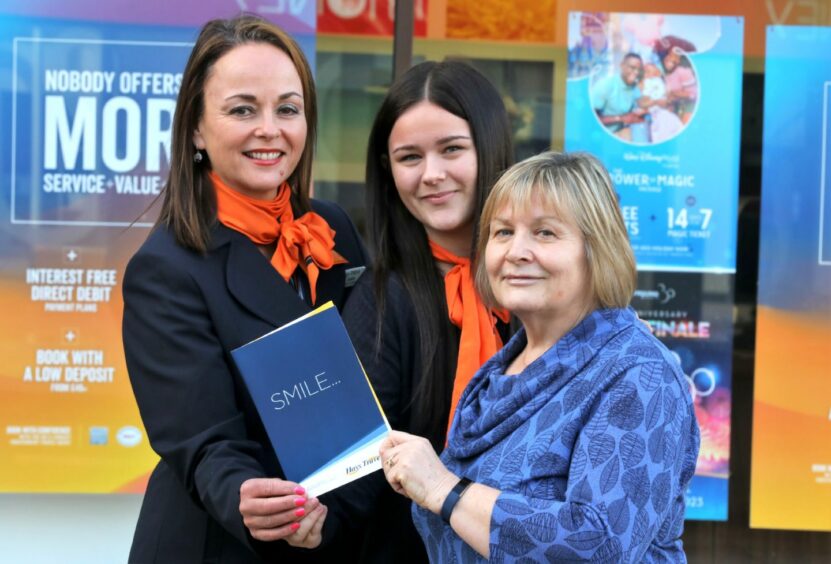 Winner Sylvia Adams, from Carnoustie, is presented with her flight tickets by Sophie McFadyen &amp; Joanne Stewart