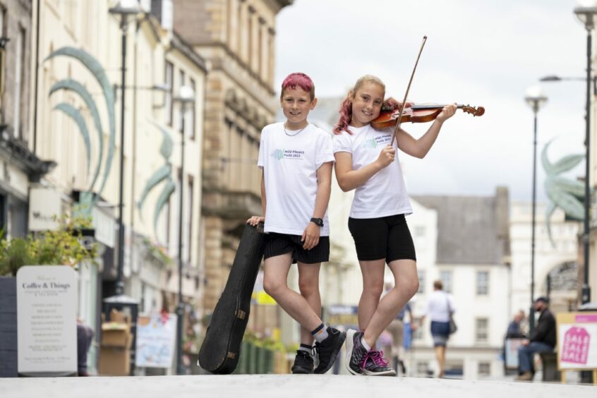 Elizabeth Maclean, 11, of the Goodlyburn Gaelic Medium in Perth, performs in the city centre with her brother James, 9, at the launch of the Royal National Mòd