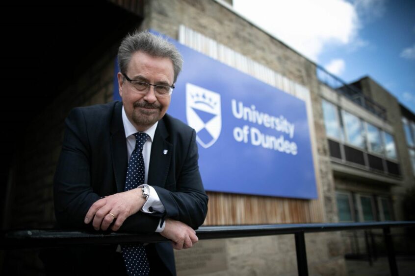 Professor Iain Gillespie in front of a sign for the University of Dundee.
