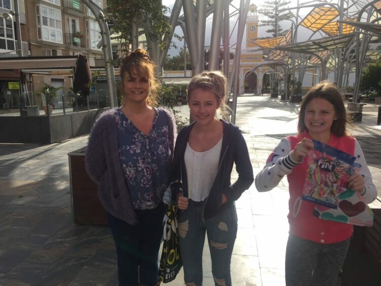 Seuna Walker and her daughters in a sunny shopping arcade on holiday.