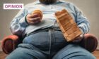 overweight man eating a burger on a sofa