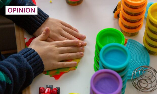 child playing with play items in a nursery setting.