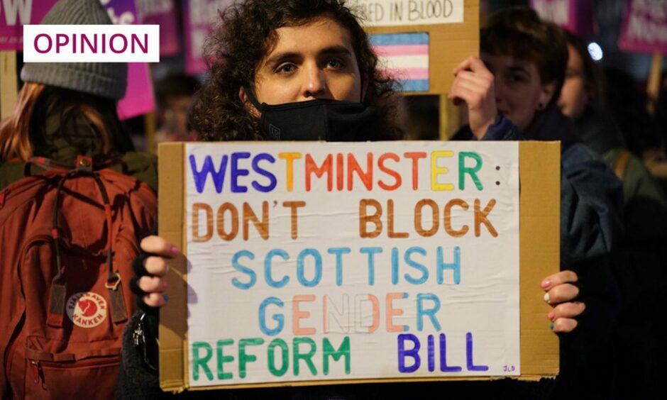protester holding a placard which reads 'Westminster: don't block Scottish gender reform bill'.