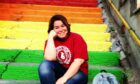 Dr Yasemin Acar in Istanbul engaging. She is passionate about climate activism and believes it can benefit people mentally. This image shows Yasemin sat on rainbow-coloured staircase.