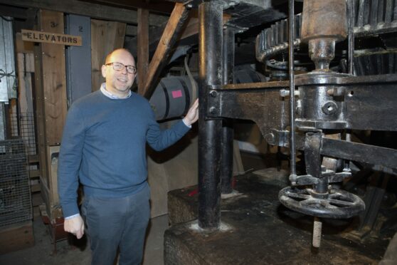 David Burrows, Lower City Mills development officer, beside machinery inside the mill. Image: Phil Hannah