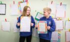 Two children holding essays for Claypotts Castle Reasons to Write event.