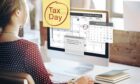 Woman sitting at computer doing her self assessment tax returns for 2022.