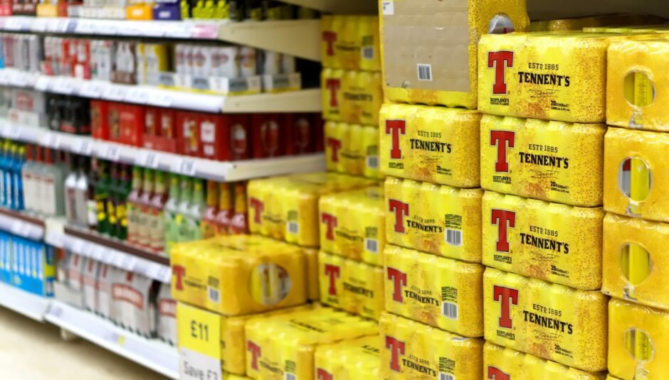 Stacked cans of Tennents lager in a Scottish supermarket.