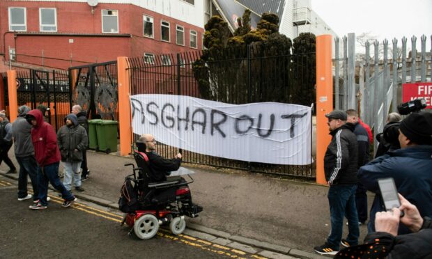 An "Asghar Out" banner on the gates of Tannadice. Image: SNS