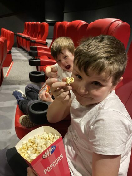 The writer's two small sons eating popcorn on a trip to the cinema.