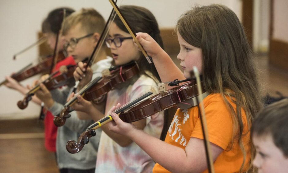 Children learn to play violin at Big Noise Douglas.