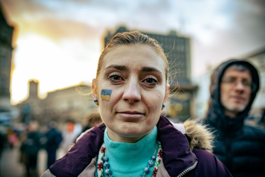 A woman with the Ukrainian flag painted on to her face at the Dundee rally. Image: Blair Dingwall/DC Thomson