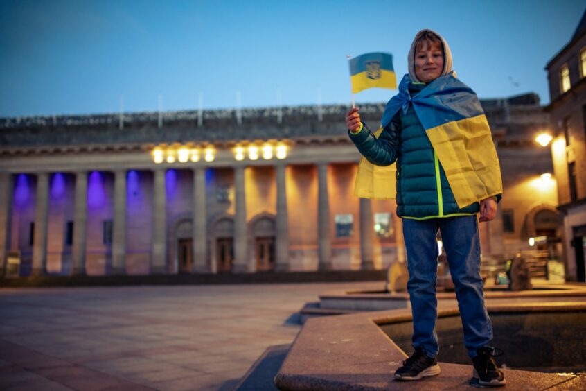 A young Ukrainian flies the flag of his homeland outside the Caird Hall. Image: Blair Dingwall/DC Thomson