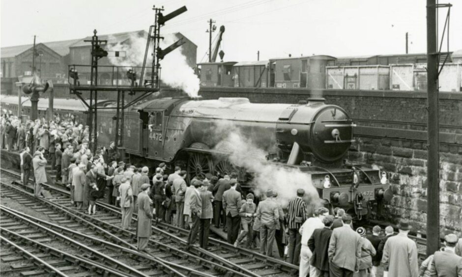 Alec Cowper's iconic shot of the Flying Scotsman and rail fans on the tracks at Tay Bridge Station in 1964.
