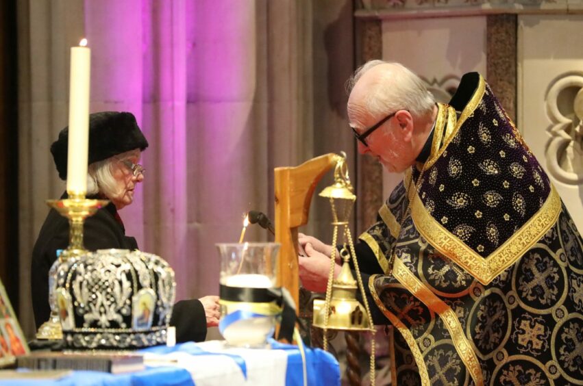 Protopresbyter Bohdan Matwijczuk lights a candle.