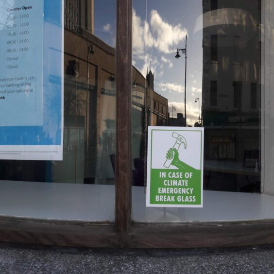 Dundee Extinction Rebellion members have left signs on Barclays windows in Dundee.