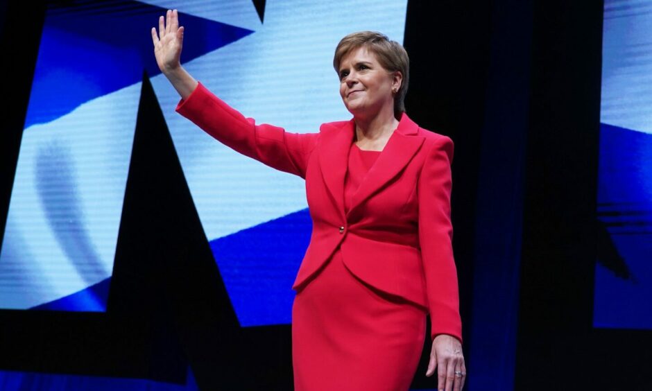 Nicola Sturgeon waving from a stage
