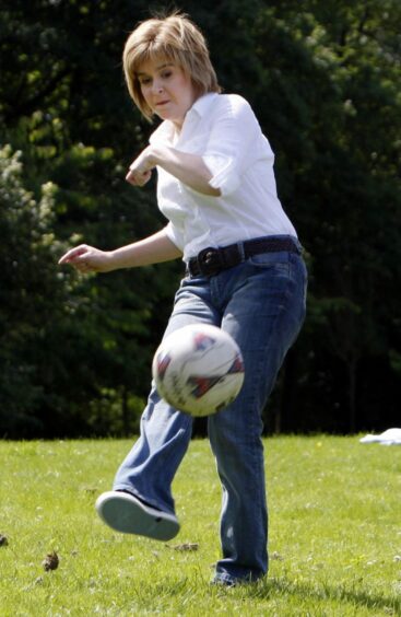 Nicola Sturgeon in jeans kicking a football in 2008.