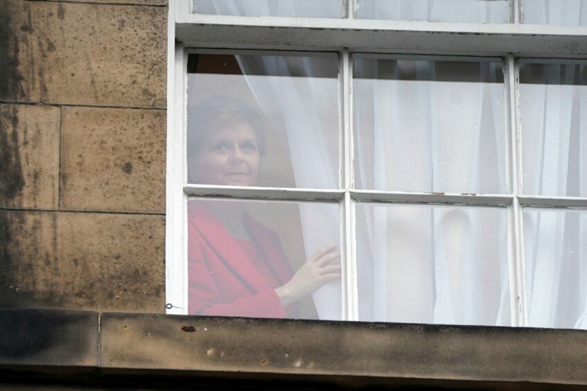 Nicola Sturgeon looking out of window at her official residence Bute House